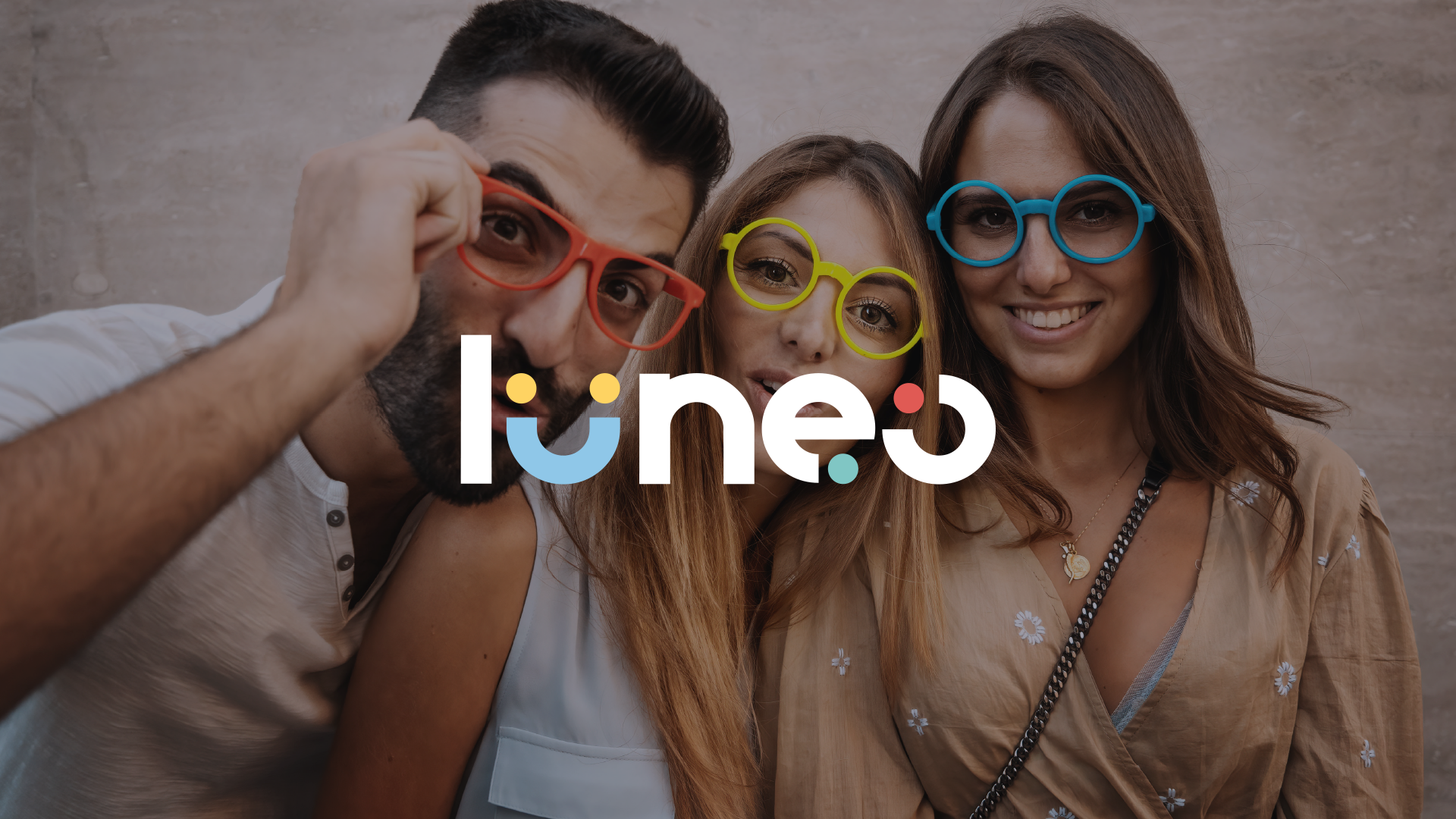 Trois jeunes adultes portant des lunettes colorées sous le logo Lunéo Opticiens.